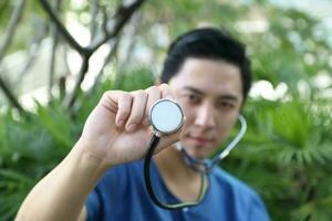 sul leste ásia jovem malaio chinês homem médico médico aguarde estetoscópio para Câmera foto