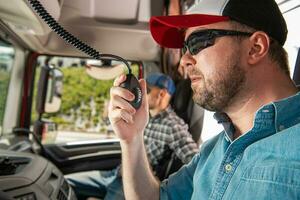 jovem caminhão motorista chamando companheiro motoristas usando cb rádio foto