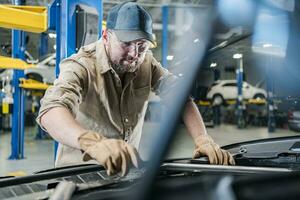 concessionária auto serviço técnico trabalhador realizando uma carro manutenção foto