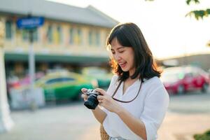 retrato do ásia mulher viajante usando Câmera às rua do Bangkok, tailândia. Ásia verão turismo período de férias conceito foto