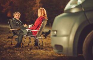 homens e mulher conversando em uma área de camping Próximo para campista furgão foto