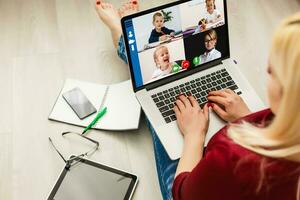 cortada imagem do jovem mulher usando computador portátil para vídeo conferência às casa foto