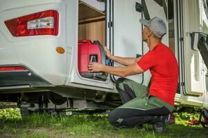 homens removendo portátil gás gerador a partir de dele campista furgão rv armazenamento área foto