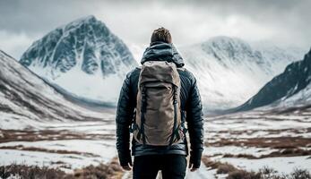 costas Visão do uma homem com mochila ficar de pé dentro frente do Alto montanha cobrir com neve, desafio conceito, ai generativo foto