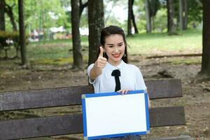 jovem ásia chinês mulher ao ar livre parque campus livro Arquivo pasta computador portátil computador telefone sentar ficar de pé estude misturar-se foto