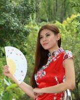 jovem sul leste ásia chinês homem mulher tradicional traje chinês Novo ano cumprimento ao ar livre às têmpora foto