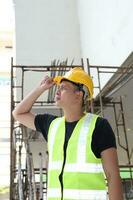 sul leste ásia jovem malaio chinês homem mulher vestindo em segurança capacete construção local trabalhos foto