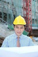 sul leste ásia jovem malaio chinês homem mulher vestindo em segurança capacete construção local trabalhos foto