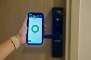 mão usando Smartphone para aberto digital porta trava às casa ou apartamento. nfc tecnologia, impressão digital Varredura, cartão de acesso, PIN número, Smartphone, elétrico e sem contato estilo de vida conceitos foto