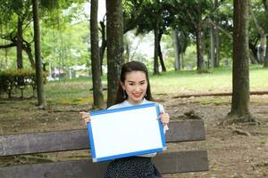 jovem ásia chinês mulher ao ar livre parque campus livro Arquivo pasta computador portátil computador telefone sentar ficar de pé estude misturar-se foto