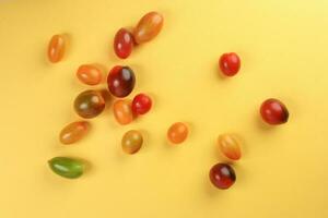 fresco maduro misturado tomate verdade sortido cor em amarelo fundo foto