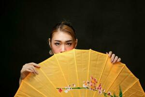 ásia mulher dentro tracional kebaya atrás guarda-chuva em Preto fundo foto