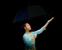 ásia mulher dentro tracional kebaya carregando guarda-chuva em Preto fundo foto