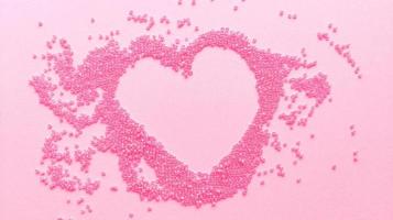 feito à mão com um coração rosa de miçangas em um fundo de textura pastel plano com espaço de cópia.
