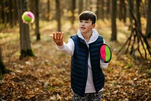 outono retrato ao ar livre de menino jogar com jogo de bola de pegar e atirar. foto