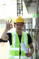 sul leste ásia jovem malaio chinês homem mulher vestindo em segurança capacete construção local trabalhos foto