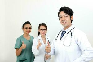 jovem ásia malaio chinês masculino fêmea médico em branco fundo polegares acima olhando às Câmera foto