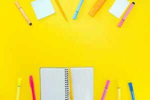 aberto caderno com caneta, marcador e em branco Páginas Próximo para colorida adesivos em amarelo fundo. cópia de espaço foto