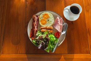 saudável café da manhã refeição do presunto, frito ovos e crocantes bacon com vegetal salada. foto