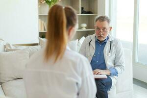 Senior homem médico examinando yound mulher dentro médico escritório ou às lar. menina paciente e médico ter consulta dentro hospital sala. remédio cuidados de saúde médico checar. Visita para doutor. foto