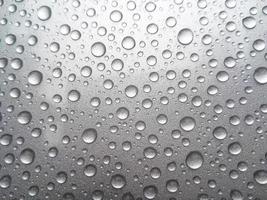 gota de orvalho da chuva em um fundo de cor cinza foto