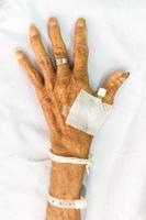 mão de paciente idoso com plug na cama no hospital