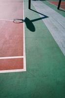 sombras de aro na quadra de basquete de rua foto