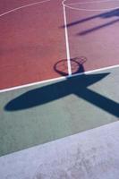 sombras de aro na quadra de basquete de rua foto