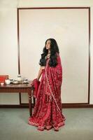 lindo jovem mulher vestindo indiano Lehenga hgagra tornozelo comprimento saia vestir posando casa retro vintage foto