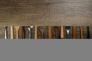 variedade do de madeira metal plástico colher cozinha talheres em rústico madeira fundo cópia de texto espaço foto