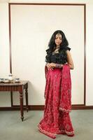 lindo jovem mulher vestindo indiano Lehenga hgagra tornozelo comprimento saia vestir posando casa retro vintage foto