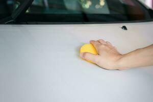 amarelo esponja polimento e limpeza a carro foto