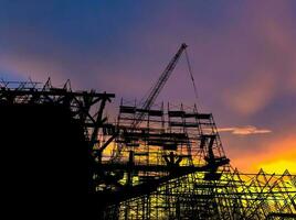 a conceito do a construção indústria debaixo construção silhueta e tarde Sol foto