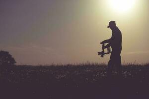 profissional cameraman filmando em nascer do sol usando gimbal estabilizador foto