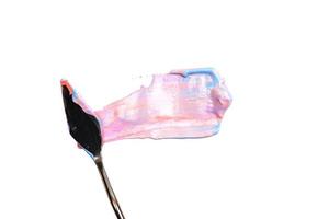 uma faca de paleta de pintura isolada em um fundo branco pintando um rosa e violeta com espaço de cópia foto