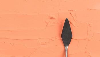 uma faca de paleta de pintura isolada em um fundo pintado de laranja pintura com espaço de cópia