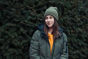 retrato de uma linda garota sorridente perto de uma árvore de Natal ao ar livre foto