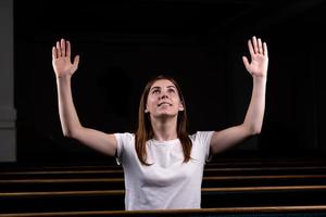 uma menina cristã orando com o coração humilde na igreja foto