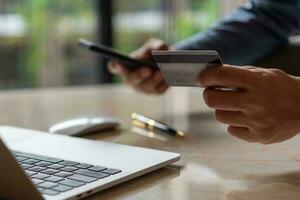 homem mãos segurando crédito cartão usando Internet Forma de pagamento computador portátil computador, conectados compras digital bancário, o negócio financeiro tecnologia conceito. foto