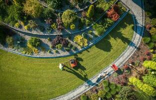 aéreo Visão do profissional jardim trabalhador com empurrar espalhador foto