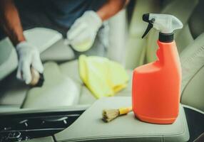 homens limpeza veículo interior usando saneando detergente foto