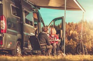 casal jogando xadrez Próximo para seus campista furgão rv foto