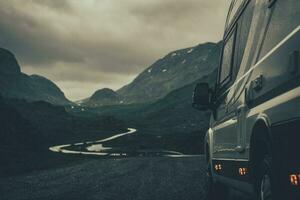 campista furgão rv em uma chuvoso escandinavo estrada foto