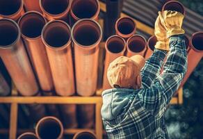 construção trabalhador comprando plástico sanitário servidor linha tubos foto