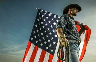 vaqueiro com americano bandeira e uma corda dentro dele mãos foto