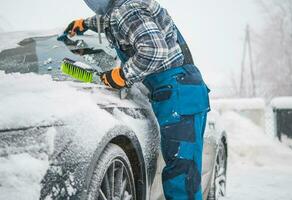 homens removendo fresco caído neve a partir de dele carro foto