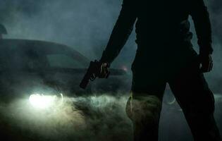 quadrilha membro com revólver dentro frente do dele carro durante noite horas foto