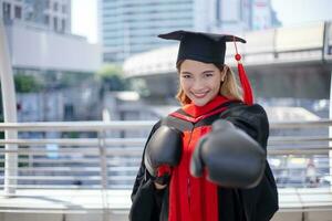 feliz ásia aluna graduado com boxe luvas. foto