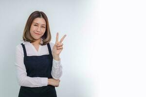 empresária asiática apontando o dedo, mostrando o número dois e sorrindo. foto