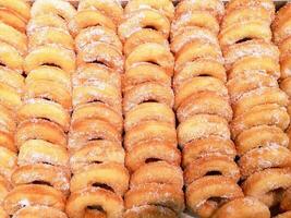 topo Visão grande quantidade do rosquinha com açúcar em estante dentro a padaria fazer compras fundo e papel de parede. rosquinha é a 1 causas doença do coronário artéria doença e obesidade. foto